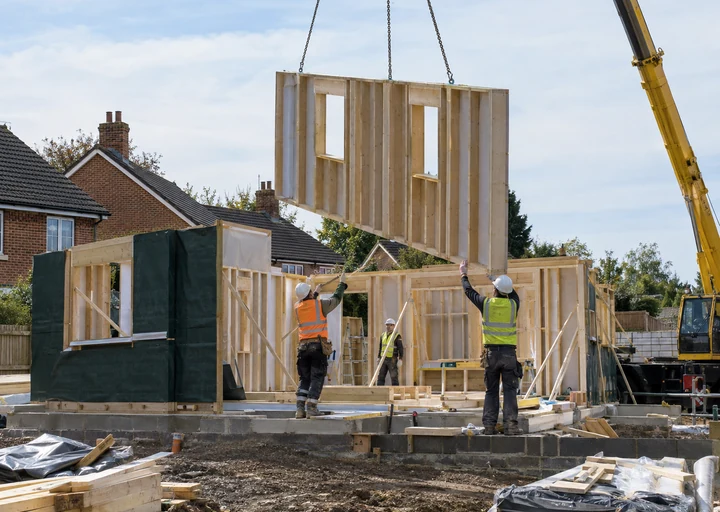 Timber-frame wall lifted by crane